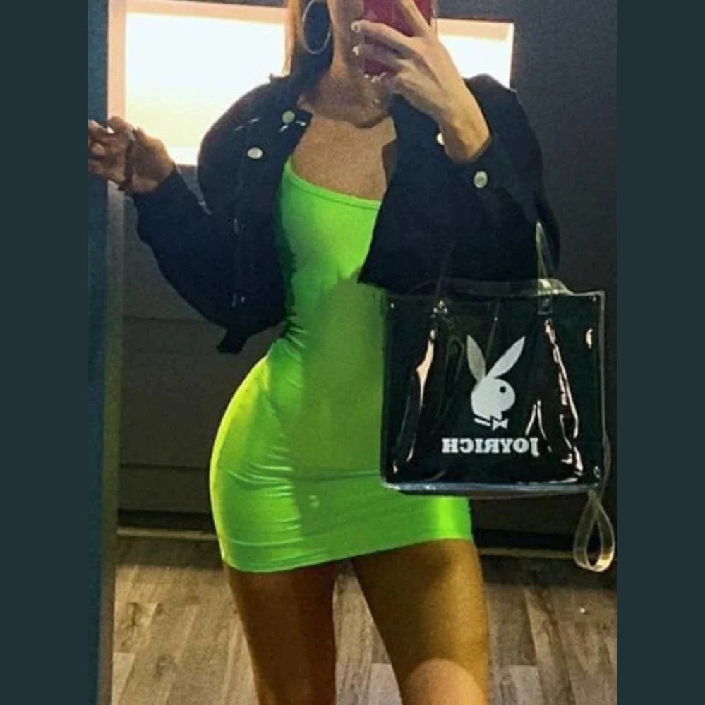 Neon green backless club party dress women wearing cropped black jacket and holding black tote bag