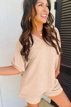Woman wearing a beige casual vacation outfit for women with short sleeves and matching shorts smiling outdoors