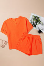 YNIQUE bright orange casual vacation outfit for women with V-neck top and elastic waist shorts