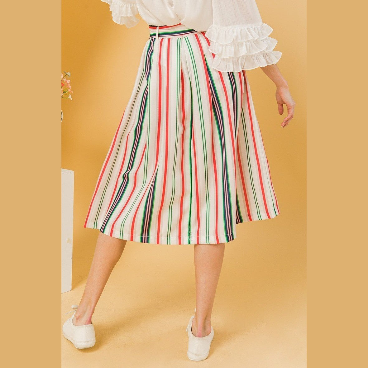 Colorful striped vacation skirt by VacationGrabs worn by woman with white blouse and white shoes