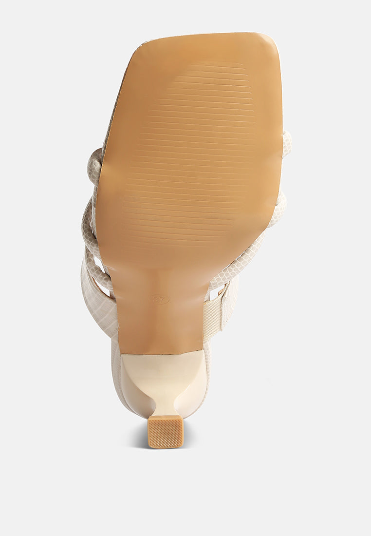 View of the sole of London Rag International criss cross strap spool heel sandals in beige color