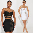 Women wearing black and white edgy party outfit for women with strappy tops and buckle detail skirts