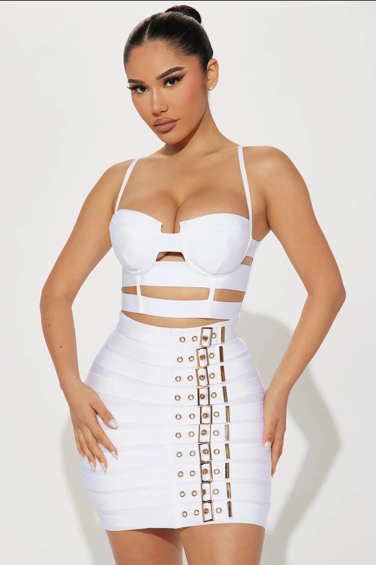 Woman wearing a white edgy party outfit for women with cutouts and buckle details