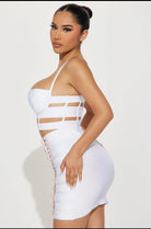 Model wearing a white edgy party outfit for women with cutouts and lace-up sides by VacationGrabs