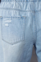 Close-up of back pocket on light wash frayed hem drawstring jean shorts by Denim Lab USA