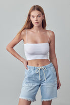 Denim Lab USA frayed hem drawstring jean shorts in light blue worn by woman with white crop top