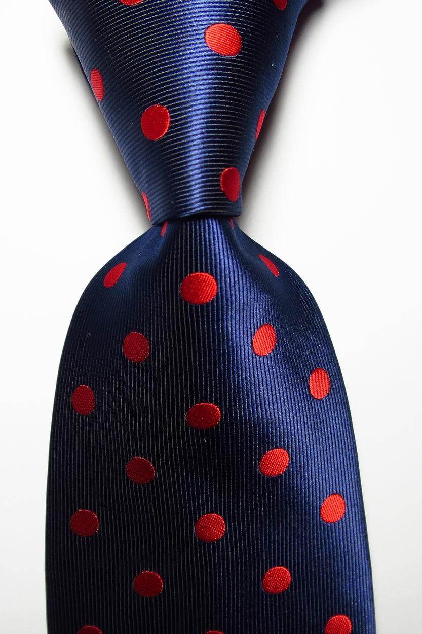 Navy blue necktie with red polka dots, perfect for stylish looks and versatile outfits