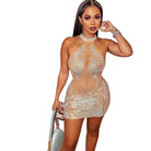 Woman wearing a mesh rhinestone mini dress with halter neck and intricate sparkling details