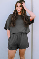 Woman wearing a gray ribbed textured matching set for women with short sleeves and elastic waist shorts
