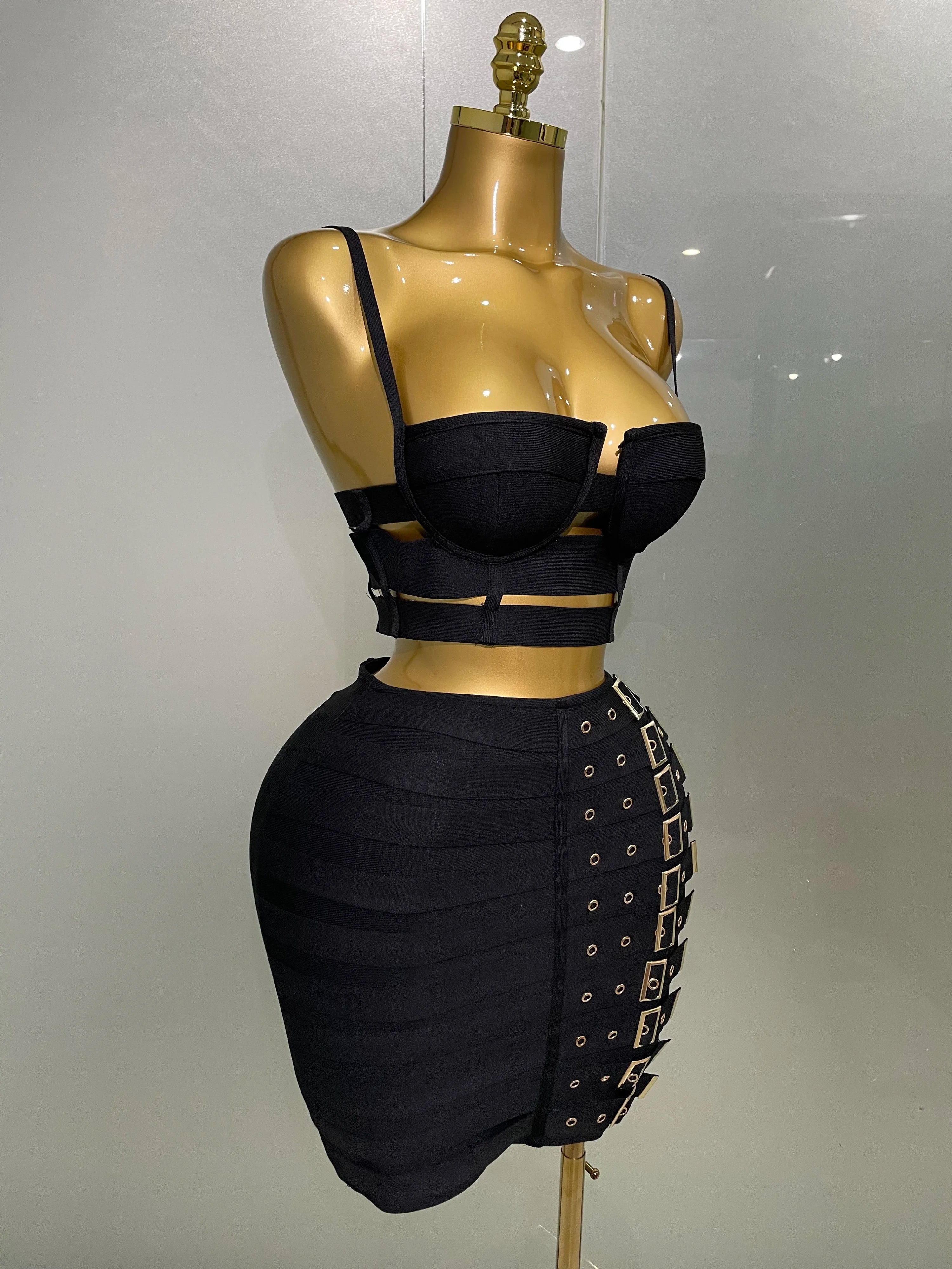 Black sexy club outfit for women featuring a strappy crop top and high-waisted skirt with buckle details