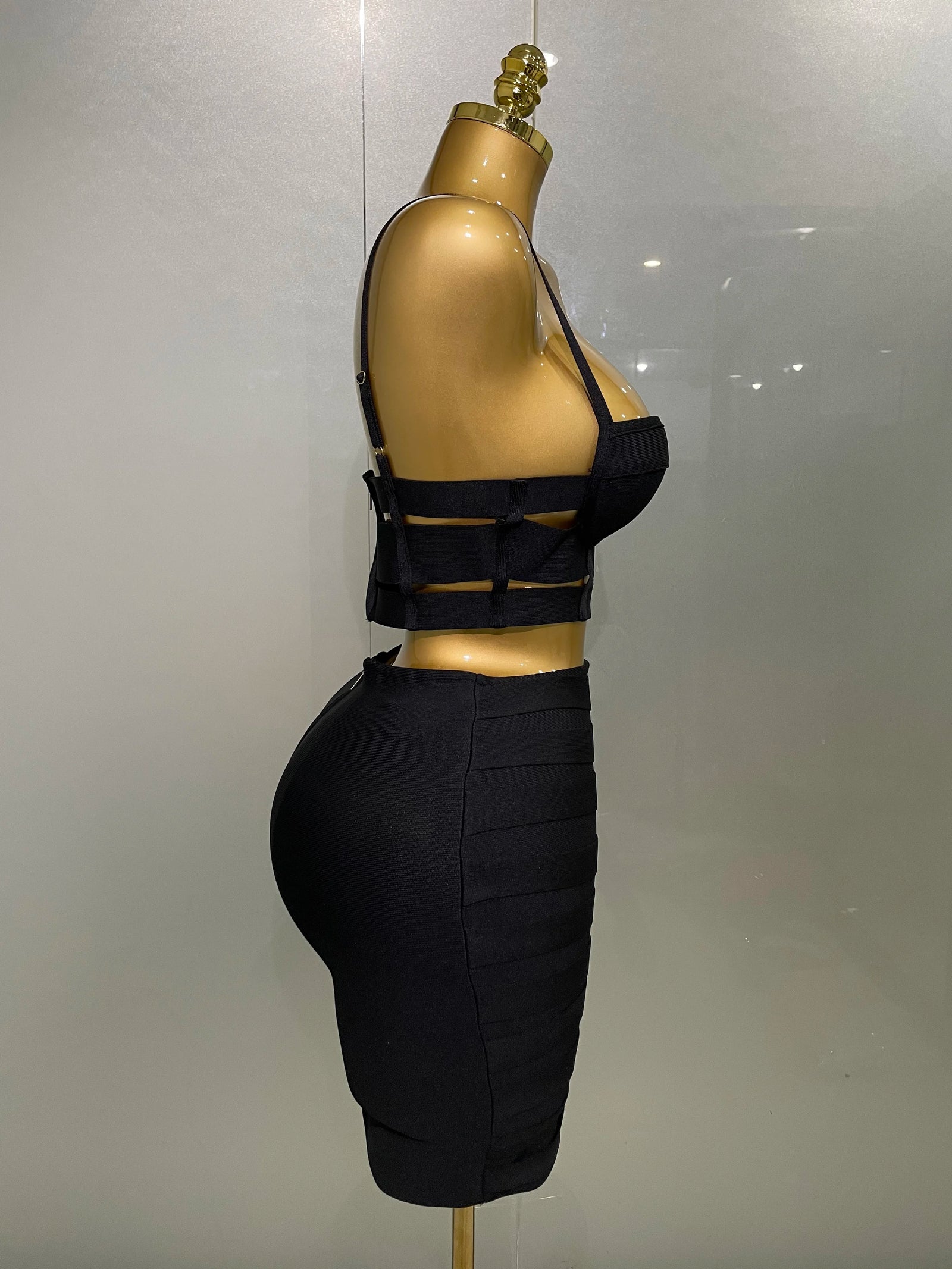 Black sexy club outfit for women featuring a strappy crop top and fitted high-waist skirt on mannequin