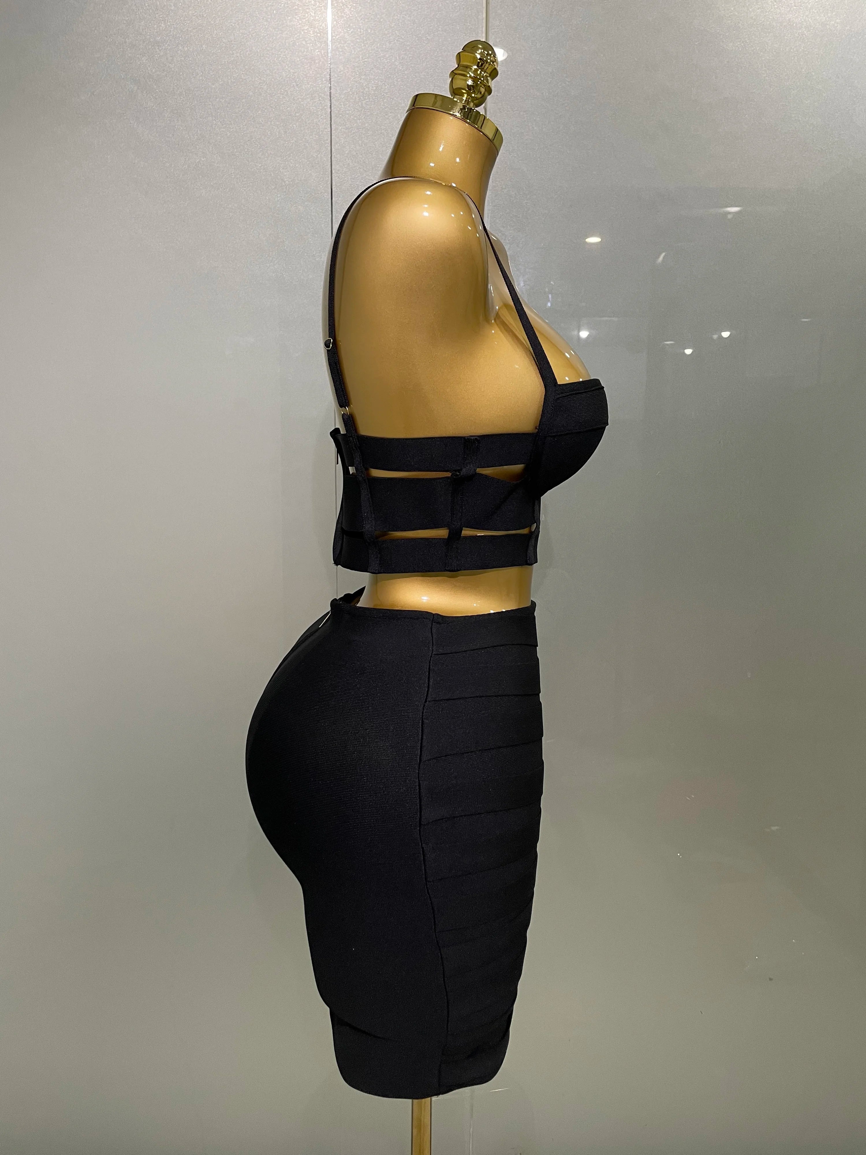 Black sexy club outfit for women featuring a strappy crop top and fitted high-waist skirt on mannequin