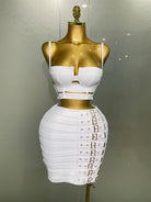 White sexy club outfit for women with strappy crop top and buckle detailed mini skirt on gold mannequin