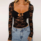 Woman wearing black sexy lace crop top set with long sleeves paired with light blue denim jeans