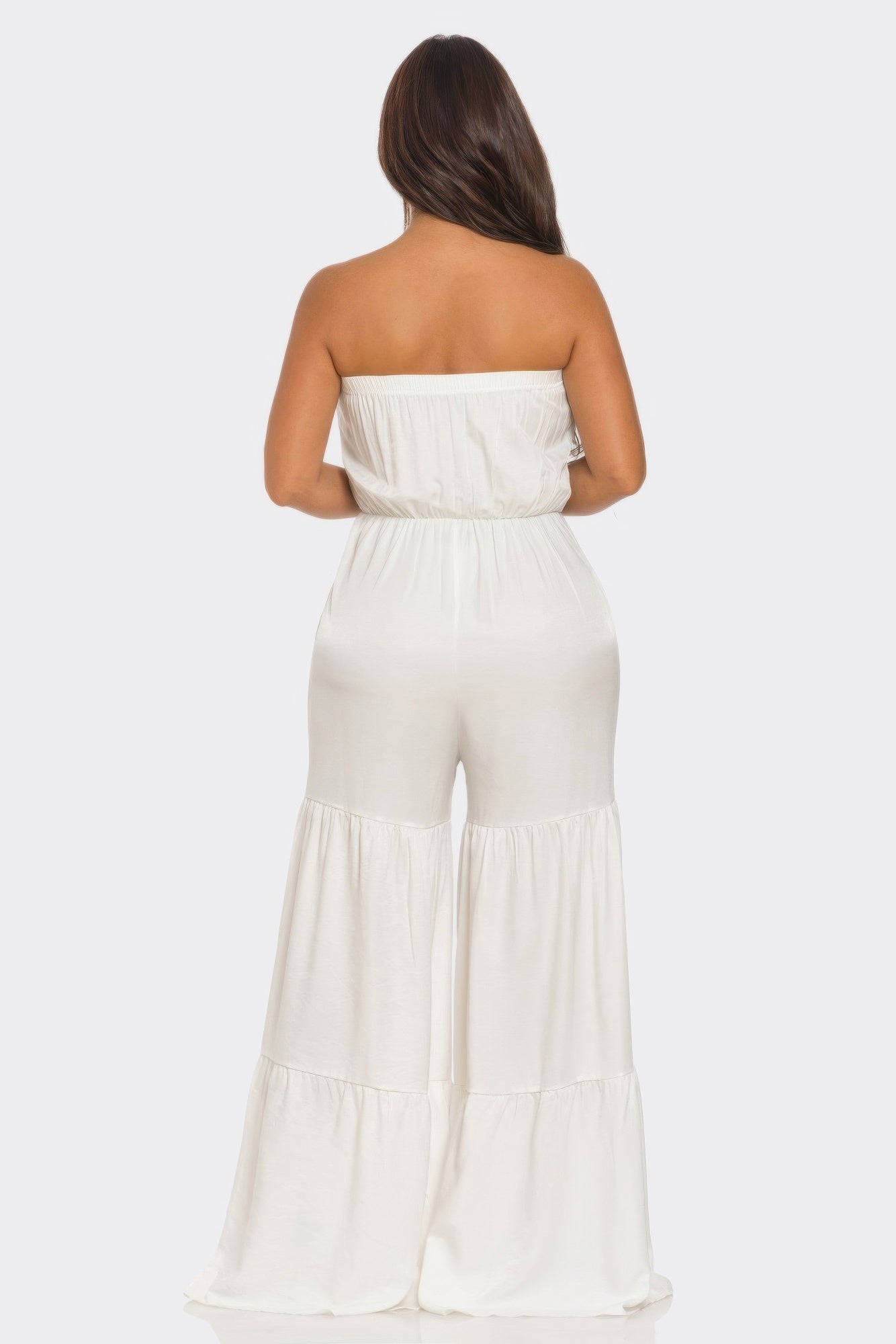 Back view of a white strapless vacation jumpsuit with flowing wide-leg design and comfortable fit