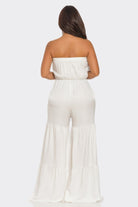 Back view of a white strapless vacation jumpsuit with flowing wide-leg design and comfortable fit