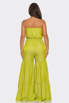 Back view of a lime green strapless vacation jumpsuit with tiered design for a stylish summer look