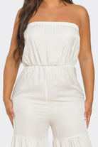 Elegant strapless vacation jumpsuit in cream with a relaxed fit and ruffled hem for comfort and style