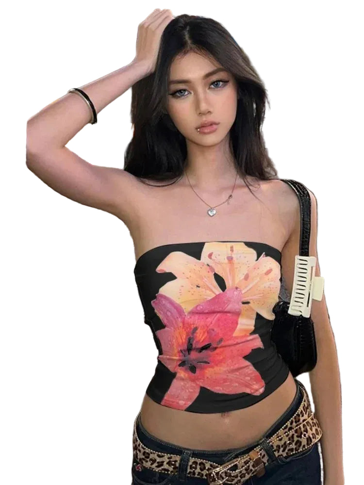 Woman wearing a black summer strapless crop top with large pink and orange floral print in city street