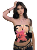 Woman wearing a black summer strapless crop top with large pink and orange floral print in city street