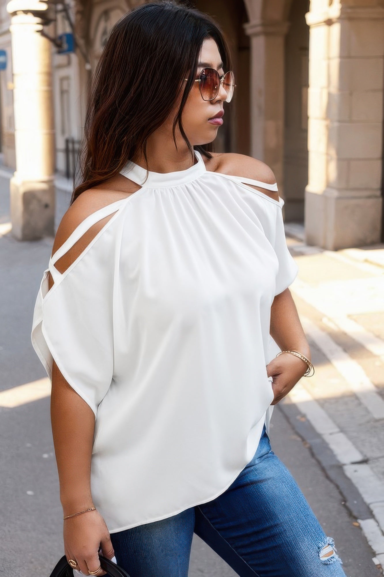 Woman wearing trendy plus size cold shoulder shirt by VacationGrabs in white with halter neck and cutout sleeves