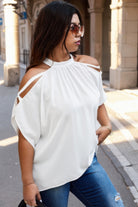 Woman wearing trendy plus size cold shoulder shirt by VacationGrabs in white with halter neck and cutout sleeves