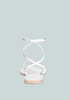 White wrap up tie flat sandals with crisscross ankle straps for a stylish summer look