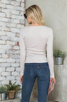 Back view of a women's versatile jersey top in light color paired with jeans for a casual look