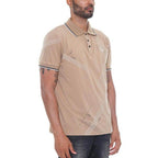 Man wearing a beige polo shirt with white stripes on a white background