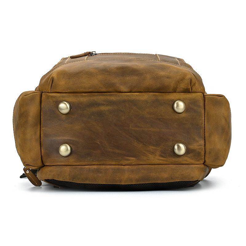 Bottom view of a vintage leather backpack with metal studs for durability and style