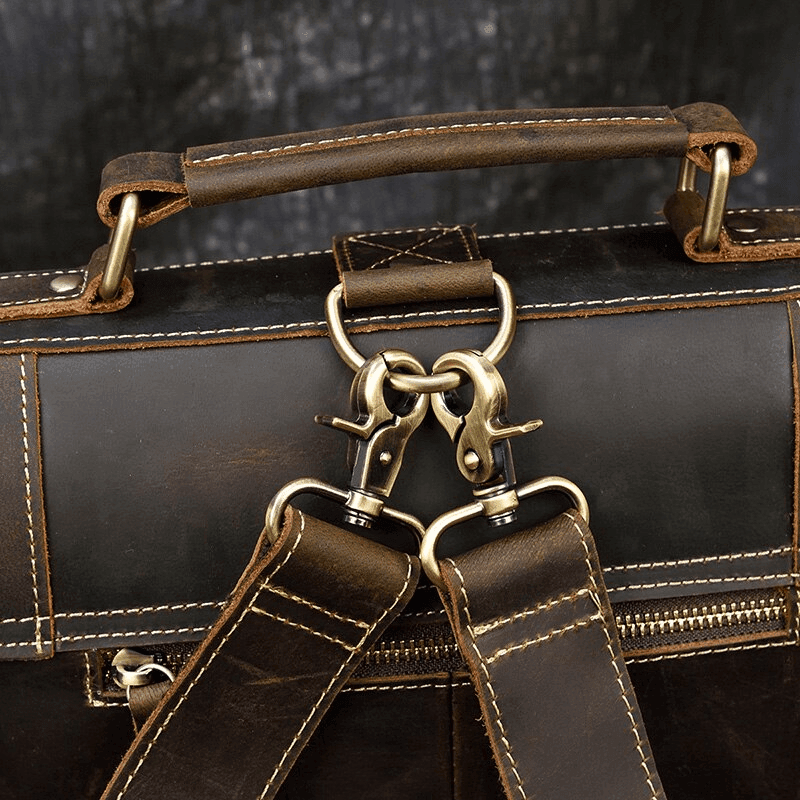 Close-up of vintage leather backpack handle and metal clasps showcasing premium craftsmanship