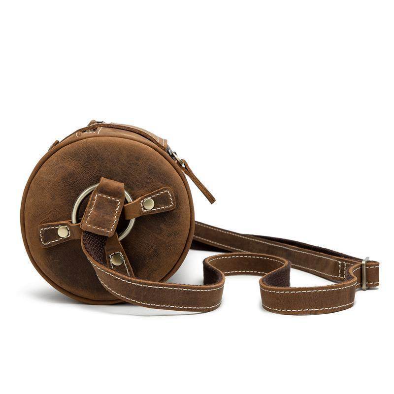 Vintage leather crossbody bag in brown with a round shape and adjustable strap for casual use