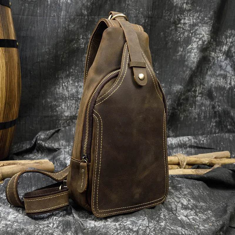 Vintage style sling bag for men in brown leather with a sleek design and zippered compartments