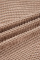 Soft fabric close-up of a JUNIPER BLVD waffle knit henley top in a warm beige tone