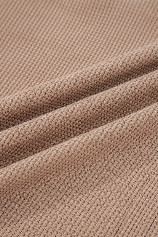 Soft fabric close-up of a JUNIPER BLVD waffle knit henley top in a warm beige tone