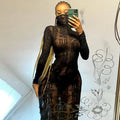 Woman wearing a black sheer long sleeve club dress taking a mirror selfie with phone