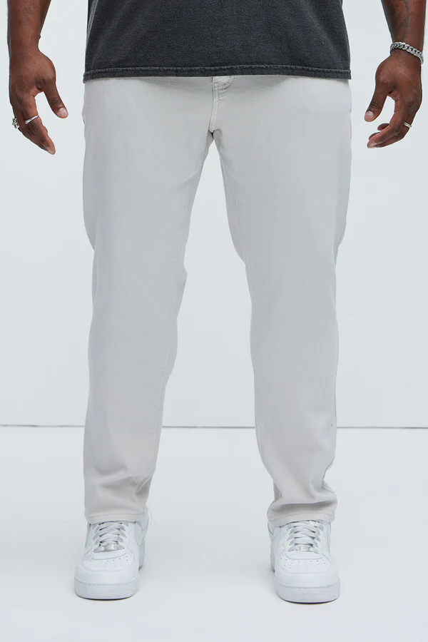 Men wearing slim fit vacation jeans men in light gray from VacationGrabs paired with white sneakers