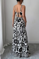 Black and white floral wide leg vacation jumpsuit featuring an open back and adjustable tie