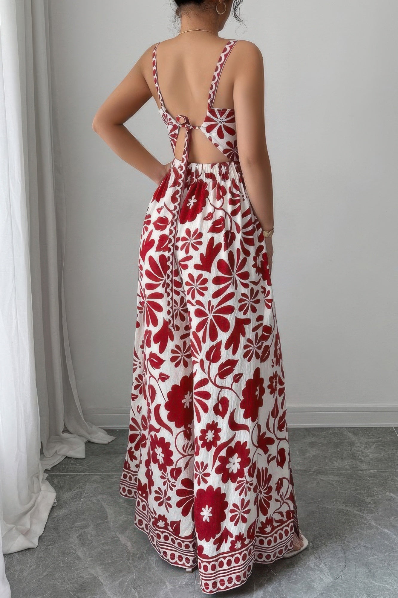 Back view of a floral print wide leg vacation jumpsuit with tied straps and cut-out design