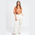 Emory Park wide sleeve crop top in orange with button detail and relaxed fit, paired with white trousers