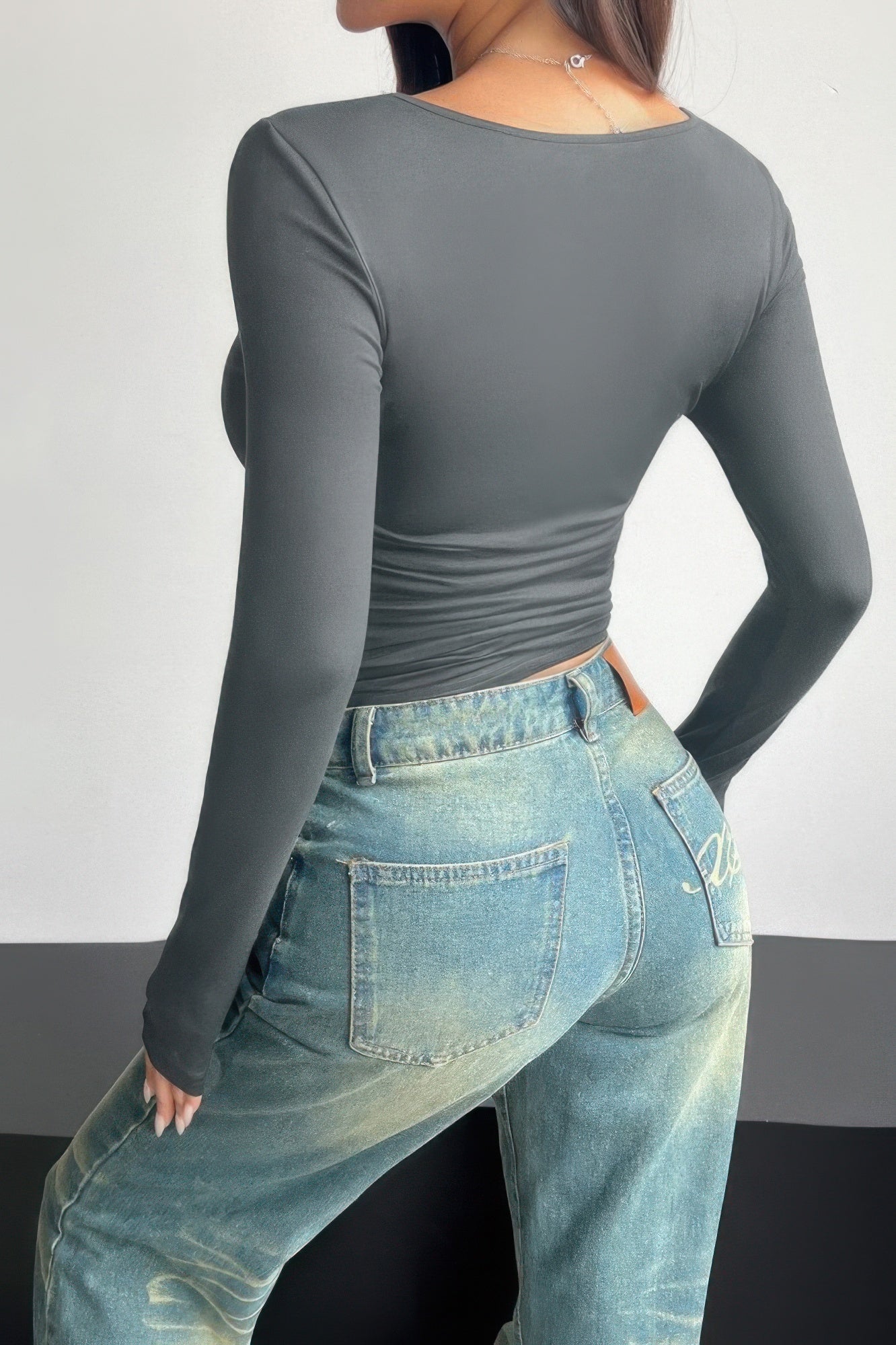 Plain black ruched tee for women with long sleeves paired with high-waisted jeans