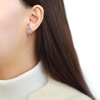 Elegant snowflake stud earrings for women worn by a model showing off a chic winter look