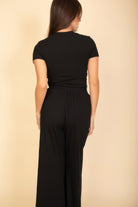 Black women's outfit with a fitted top and wide-leg pants, ideal summer travel clothes for women
