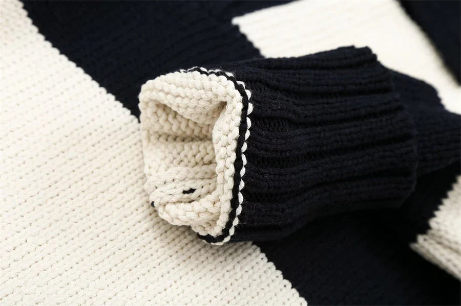 Close-up of women's black striped knit sweater showing sleeve detail and texture