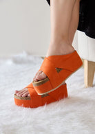 Orange womens casual flatform sandals with arch support by Maker's Shoes on model sitting on white fur rug