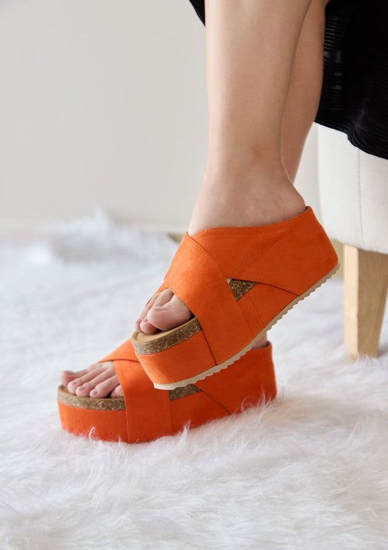 Orange womens casual flatform sandals with arch support by Maker's Shoes on model sitting on white fur rug