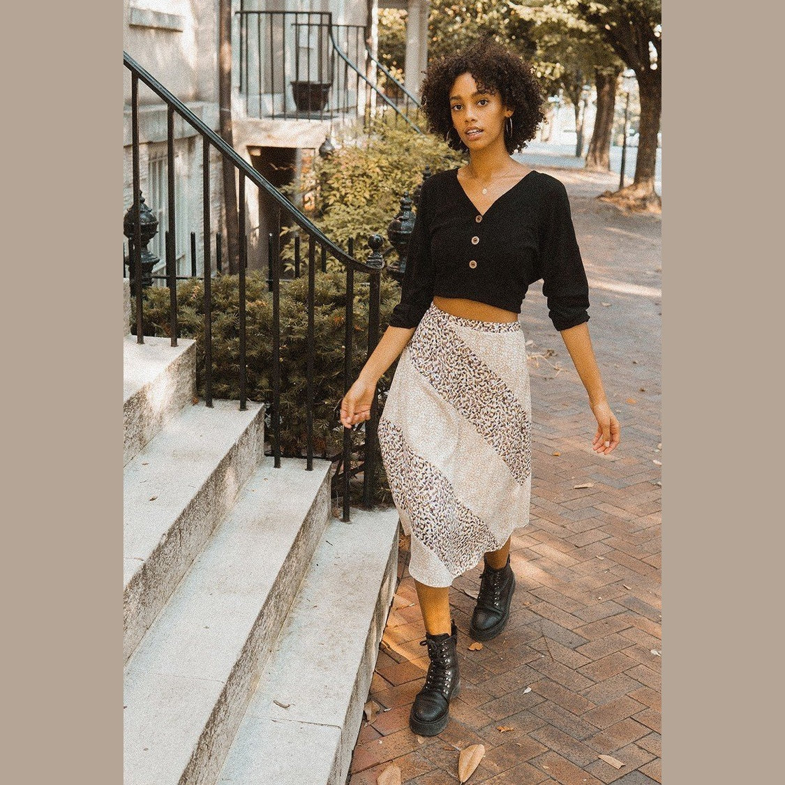 Woman wearing womens casual vacation skirts printed midi skirt paired with black cropped top and boots