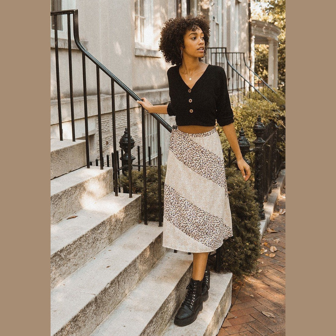 Woman wearing womens casual vacation skirts with floral print paired with black cropped top and boots