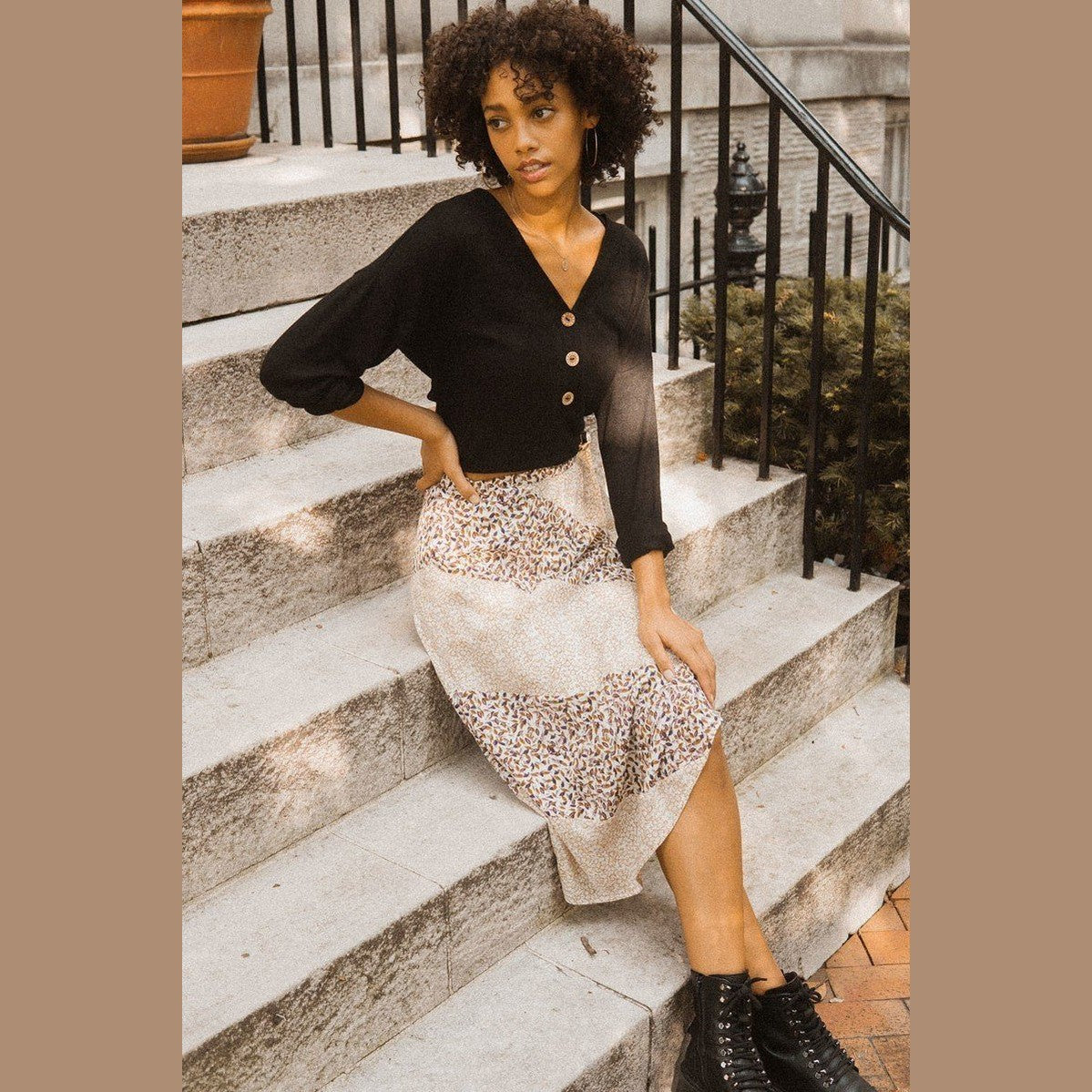 Woman wearing womens casual vacation skirts with a patterned midi design sitting on stone stairs