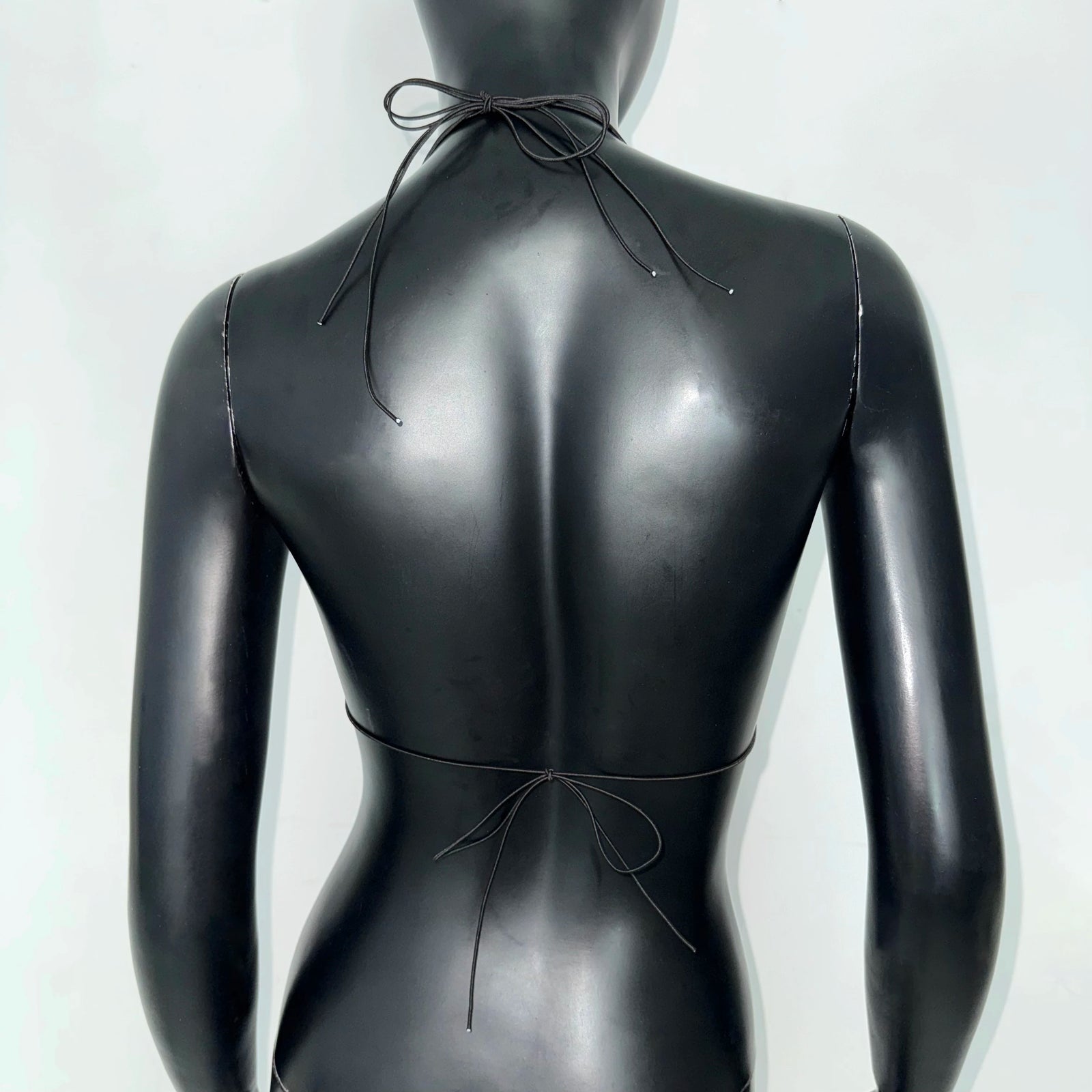 Back view of a sleek black bikini top, perfect for beach days